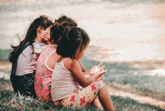 Kids sitting on a bench.